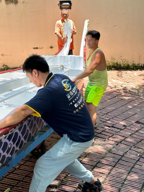師傅推台車移動龍舟
